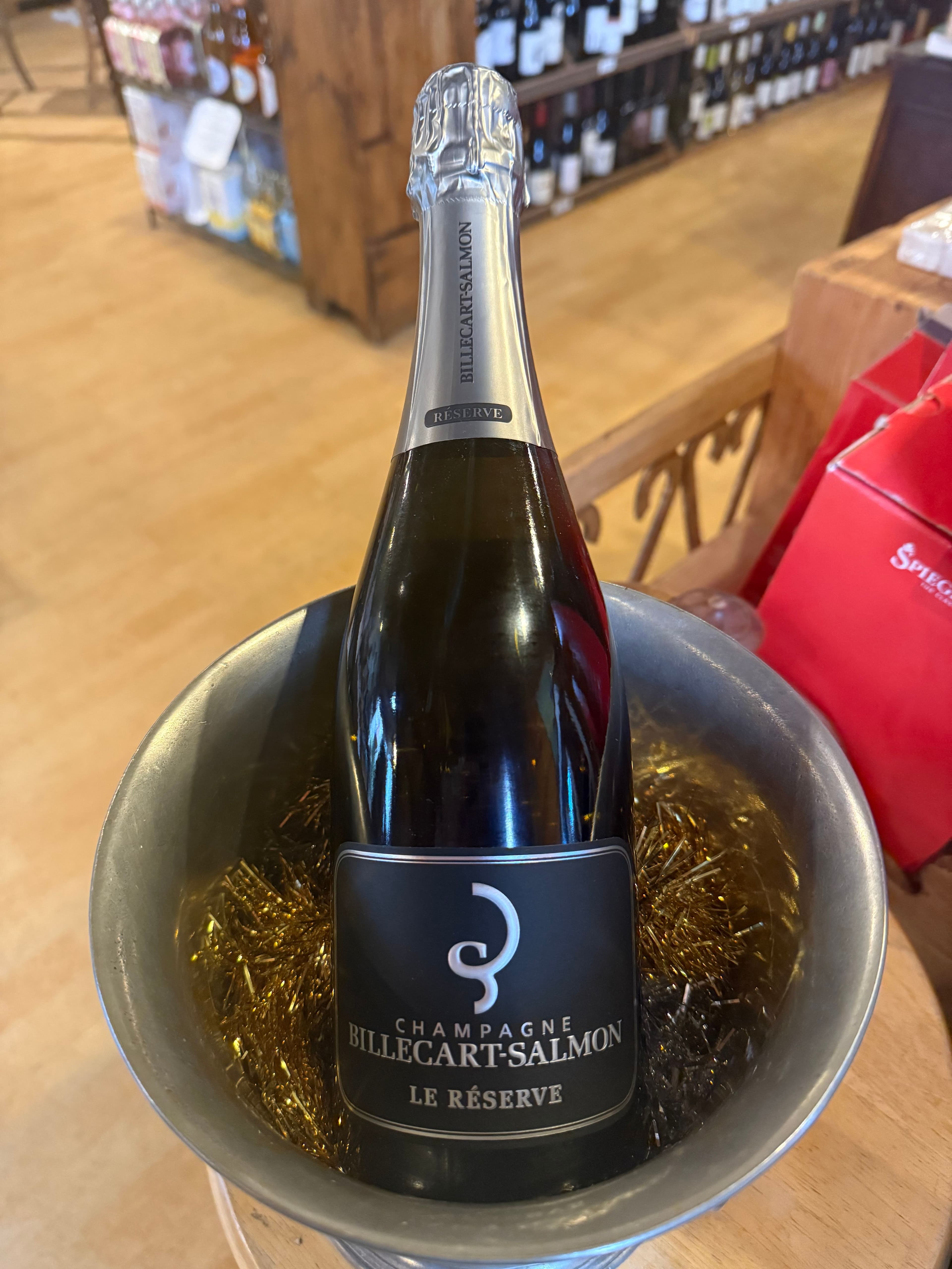A bottle of sparkling wine with two flutes by a fireplace